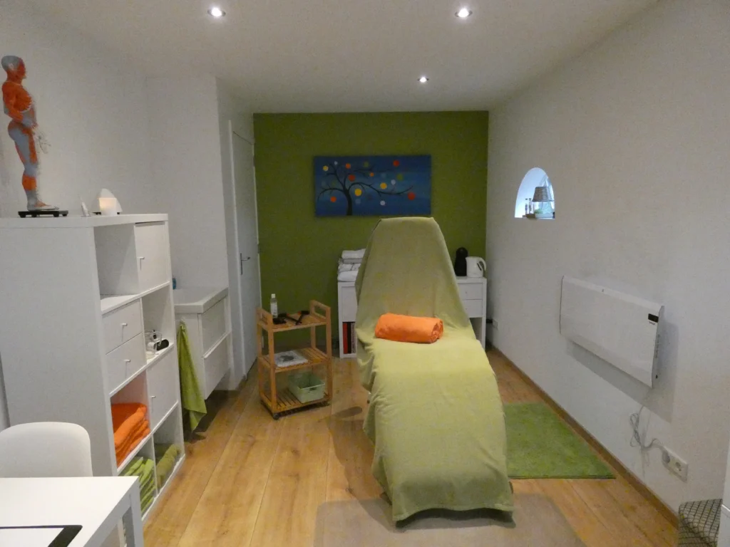 Behandelkamer van Erifar met behandelstoel, groene wand en kast met handdoeken
